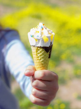 El güneş altında yaz aylarında bir waffle koni dondurma tutar. Seçici odak