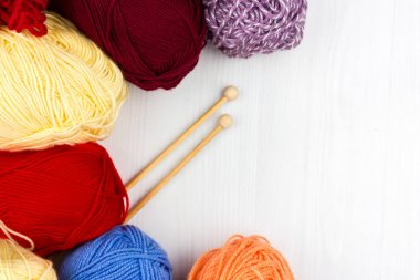 Beyaz arka planda çok renkli pastel örgü ve beyaz arka plan üzerine örme iğnelerinin düzce