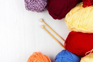 Beyaz arka planda çok renkli pastel örgü ve beyaz arka plan üzerine örme iğnelerinin düzce