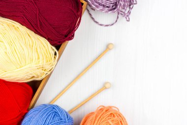 Beyaz arka planda çok renkli pastel örgü ve beyaz arka plan üzerine örme iğnelerinin düzce