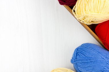 Beyaz arka planda çok renkli pastel örgü ve beyaz arka plan üzerine örme iğnelerinin düzce