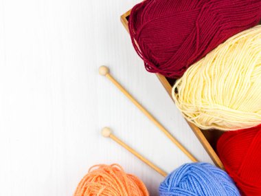 Beyaz arka planda çok renkli pastel örgü ve beyaz arka plan üzerine örme iğnelerinin düzce