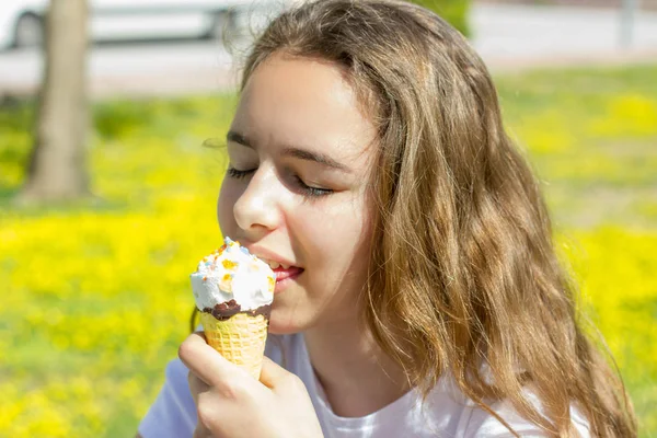 Красивая девочка-подросток ест мороженое в вафельном рожке летом. Селективный фокус — стоковое фото
