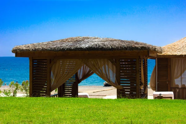 Paviljong med halmtak på en sandstrand. Medelhavet sommar-och havs — Stockfoto