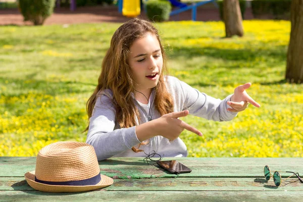 Menina adolescente bonita emotiomally conta a história no parque de verão — Fotografia de Stock