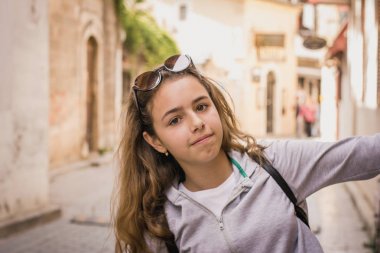 Young beautiful girl walks along the stone street of the old city of Antalya