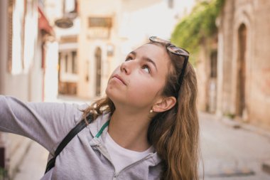 Young beautiful girl walks along the stone street of the old city of Antalya