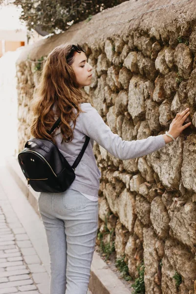 Jong mooi meisje staat in de buurt van de oude stenen muur van de oude stad van Antalya — Stockfoto