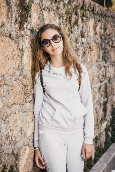 Menina bonita jovem fica perto da antiga parede de pedra da cidade velha de Antalya — Fotografia de Stock