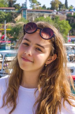 Young girl with long hair on the pier in the yacht port