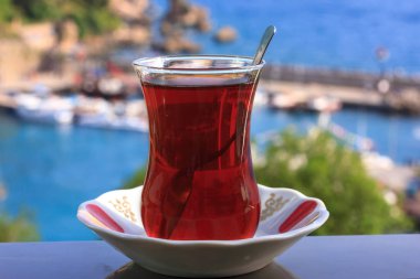 Mavi Akdeniz'in arka planında geleneksel camda Türk siyah çayı