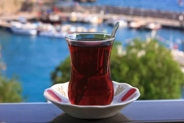 Chá preto turco em vidro tradicional no fundo do mar Mediterrâneo azul — Fotografia de Stock