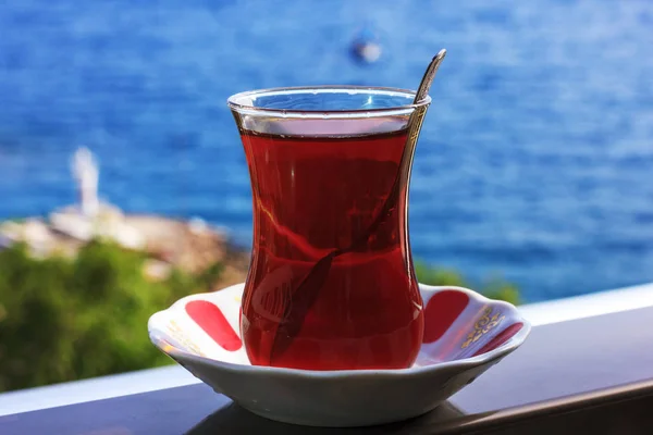 Té negro turco en vidrio tradicional sobre el fondo del mar Mediterráneo azul — Foto de Stock