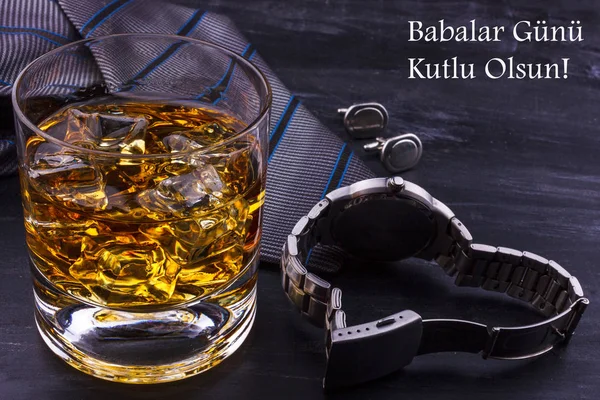 Male concept for father\'s day. Tie, watches, cufflinks and a glass of whiskey with ice. Lettering in turkish language - Happy father\'s day