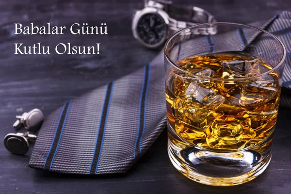 Male concept for father\'s day. Tie, watches, cufflinks and a glass of whiskey with ice. Lettering in turkish language - Happy father\'s day