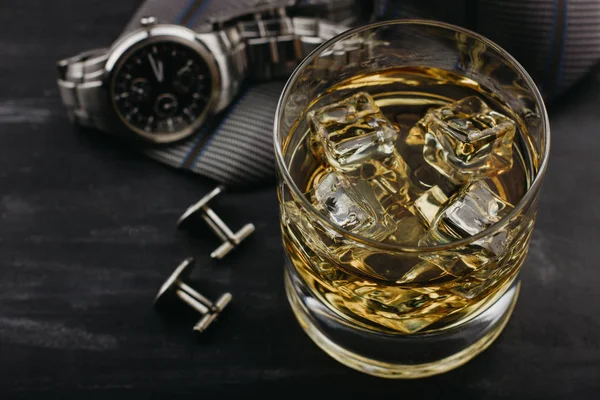 Concepto masculino para el día del padre. Corbata, relojes, gemelos y un vaso de whisky con hielo — Foto de Stock