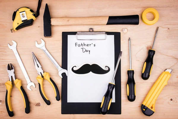 Repair tools - hammer, screwdrivers, adjustable wrenches, pliers. Sheet of white paper. Male concept for father's day