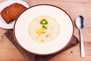 Kızarmış ekmek ile beyaz bir tabakta peynir çorbası