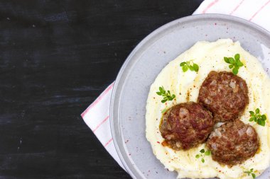 Taze fesleğen ile süslenmiş gri bir plaka üzerinde patates ve et topları püresi