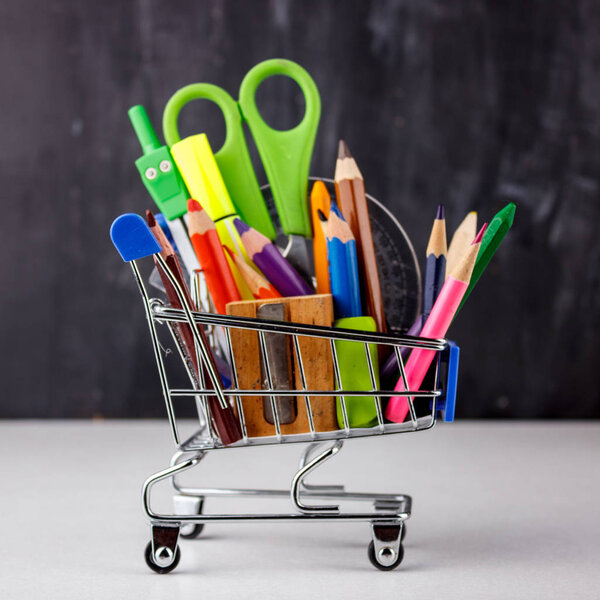 Set of colored pencils and markers for school. Stationery for the student - scissors, sharpener, eraser in a shopping cart