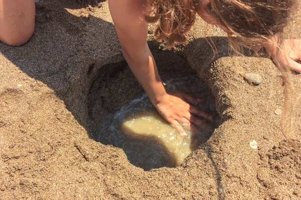 Jeune jolie adolescente bronzée fille construire un château de sable sur la plage près de la mer — Photo