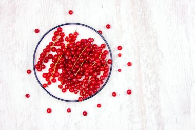 Olgun kırmızı üzümler. Masadaki üzümler beyaz tabakta.