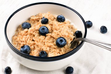 Taze yaban mersinli yulaf ezmesi. Diyet yemek - kaşıkla tabakta yulaf lapası.