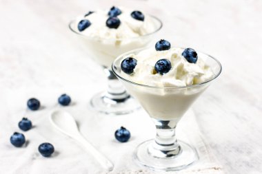 Diyet yoğurt ve büyük taze yaban mersini. Bardakta şekersiz yoğurt.