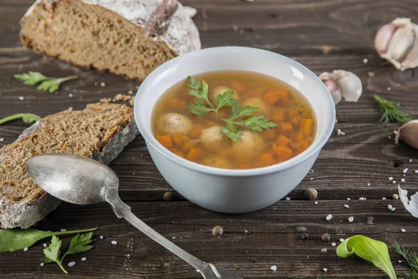 Bowl of soup, a cup of broth and vegetables, meatballs made of turkey and chicken