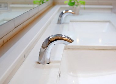 Otomatik su dokunun ve beyaz seramik lavabo