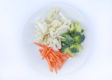 Karnabahar, brokoli ve havuç beyaz arka plan üzerinde izole bir plaka üzerinde.