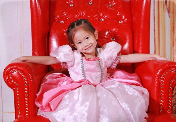 Little asian girl dressed as a princess. Child in pink princess dress over vintage background.