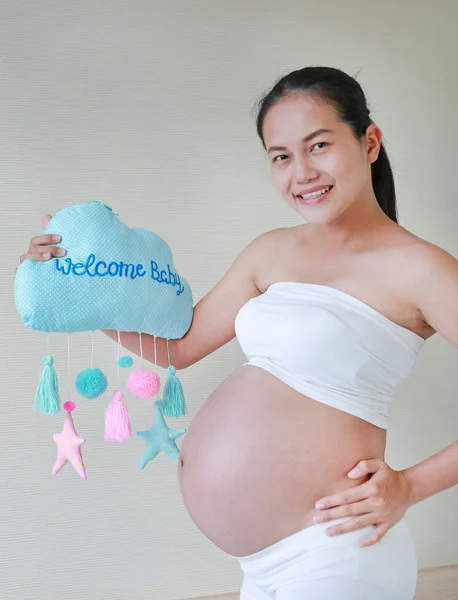 Portrait of pregnant woman holding soft fabric with text \