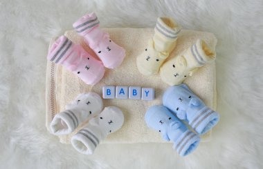 Beyaz kürk arka plan üzerinde yeni doğmuş bebekler için çorap koleksiyonu.