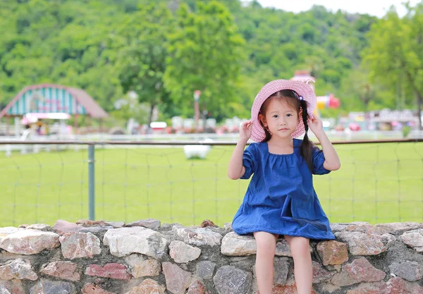 Nettes Kleines Asiatisches Mädchen Mit Strohhut Sitzt Auf Der Steinmauer — Stockfoto