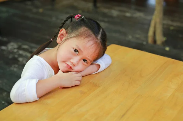 Portret Schattig Klein Meisje Liggend Lege Houten Tafel Direct Kijken — Stockfoto