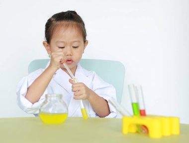 Asyalı çocuk bilim adamı beyaz arka plan üzerinde izole sıvı ile test tüpü tutan tek tip