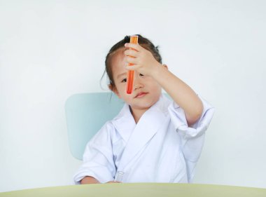 Asyalı çocuk bilim adamı beyaz arka plan üzerinde izole sıvı ile test tüpü tutan tek tip