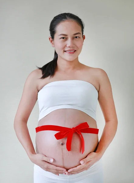 Έγκυος Γυναίκα Που Κρατώντας Την Κοιλιά Της Κόκκινη Κορδέλα — Φωτογραφία Αρχείου
