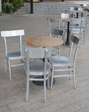 Daire ahşap masa alüminyum sandalye ile bahçede ayarla.