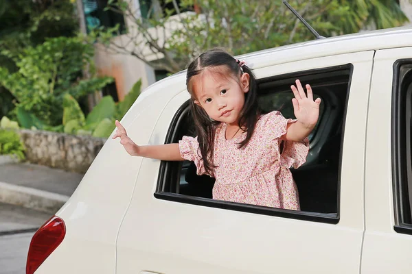 可爱的亚洲女孩在汽车后座挥手告别 — 图库照片