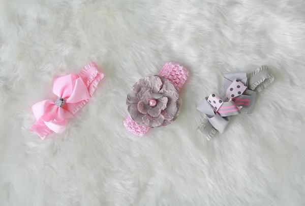 Set of pink bow for head band on white fur background. Hair accessories.