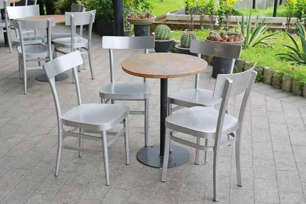 Circle wood table set with aluminium chair in the garden