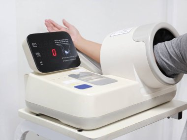 Hastaların kol otomatik tansiyon aleti yerleştirin..