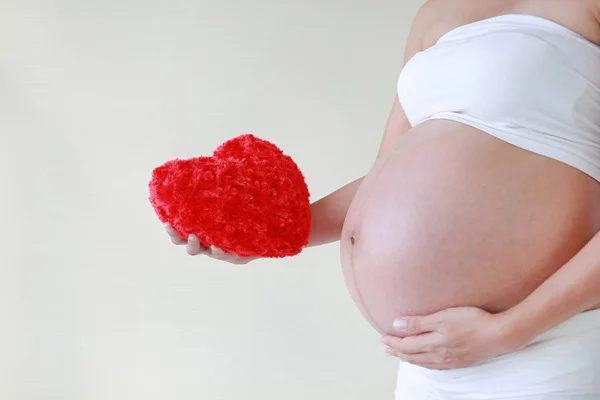 Närbild Gravid Kvinna Som Håller Röd Hjärta Kudde Hennes Mage — Stockfoto