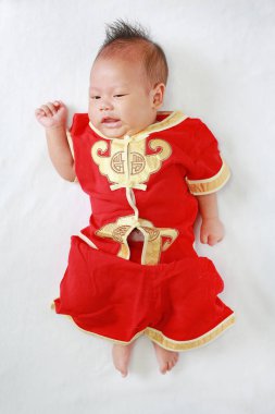 Beyaz kürk arka plan üzerinde geleneksel Çin yeni yılı festival sırasında yalan cheongsam erkek bebek bebek.