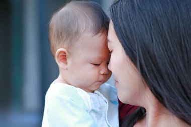 Yakın çekim yüz Asya Anne ve onun bebek.