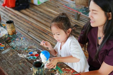 Anne ve küçük kız eğleniyor sıva bebek boya için