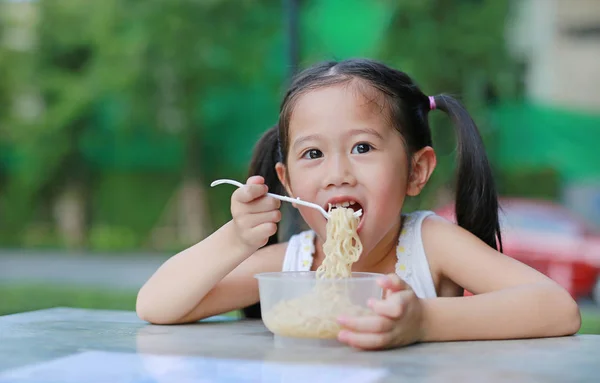 Szczęśliwy Asian Dziecko Dziewczynka Jedzenie Instant Makaron Ogrodzie — Zdjęcie stockowe