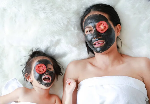 Junge Frau Und Kind Kohlepeelender Gesichtsmaske Mit Geschnittenen Tomaten Auf — Stockfoto